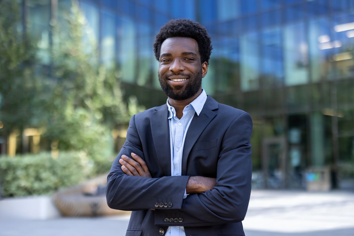 Portrait of successful confident African businessman in suit smiling and looking at camera